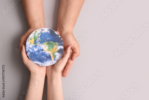 Cuadro en lienzo Female hands with paper planet Earth on grey background