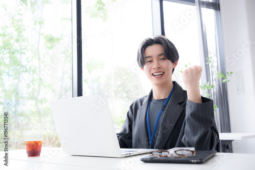 Valokuva 仕事で成果を出して喜ぶ若手社員の成功と達成のビジネスシーンのガッツポーズのカメラ目線　ポジティブ