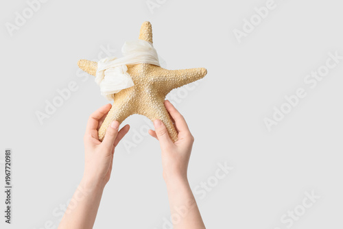 Hands holding starfish with...