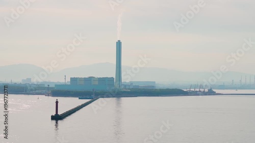 Osaka, Japan - Oct 11 2024, 4k, panoramic view from the water to the Nanko thermal power plant, with a mountains and cloudy sky, at daytime, Osaka, Japan