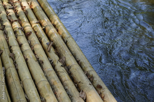 A bamboo raft positioned by the riverside in a calm natural setting.
