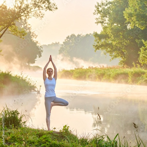 Wallpaper Mural Woman Practicing Yoga by a Misty River at Sunrise. Torontodigital.ca