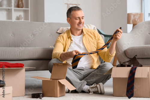 Mature man unpacking box wi...