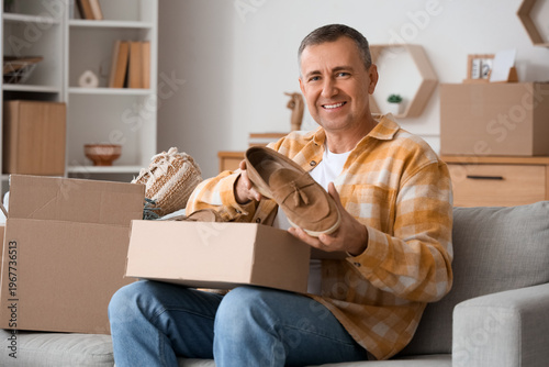 Mature man unpacking box wi...