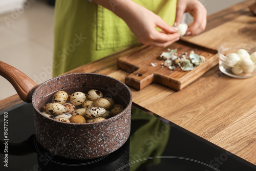 Woman peeling boiled quail ...
