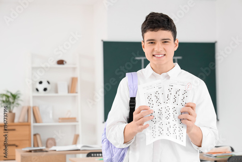 Upset teenage boy tearing a...