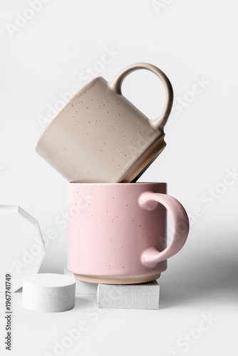 Stylish ceramic mugs on gre...