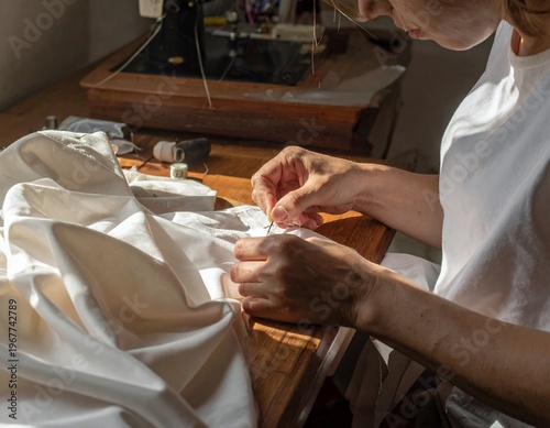 Womans Hands Meticulously Stitching Fabric in a Well-Lit Workshop.