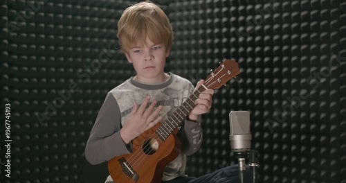Boy Play Music on Ukulele Instrument in Home Studio. 4K 10-bit