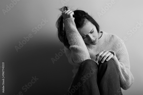 Depressed young woman on dark background . Black and white effect