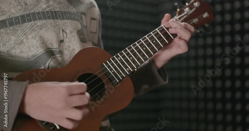 Boy Play Music on Ukulele Instrument in Home Studio. 4K 10-bit