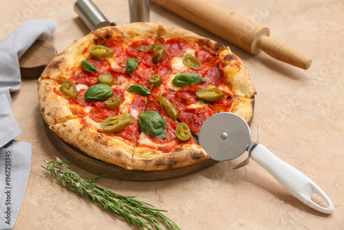 Tasty pizza and cutter on b...