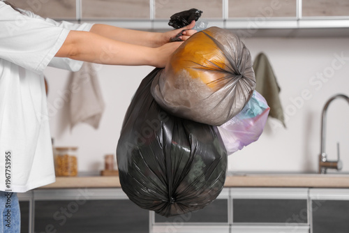 Woman with full garbage bag...