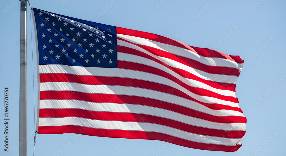 Obraz premium Full view of american flag attached to flagpole waving under clear blue sky on sunny day.