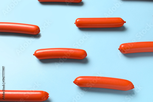 Tasty thin sausages on blue...