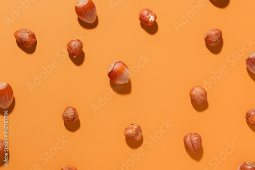 Shelled hazelnuts on orange...