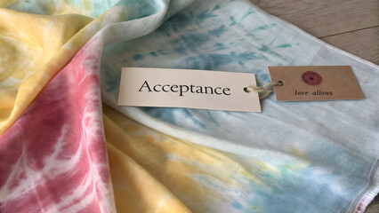 A hand dyed cotton textile with the word Acceptance on a tag