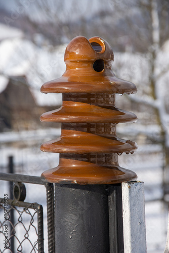  ceramic pin-type electrical insulator, commonly used on overhead power lines to prevent electrical current from flowing to the support structure. 