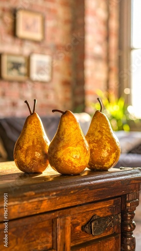 Three ripe Bosc pears on a rustic wooden dresser in a sunlit room.