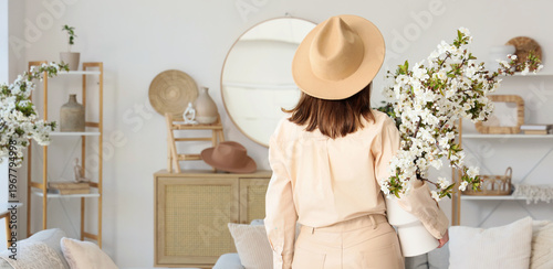 Young woman holding vase wi...