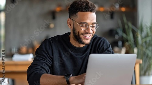 Smiling man using laptop computer.