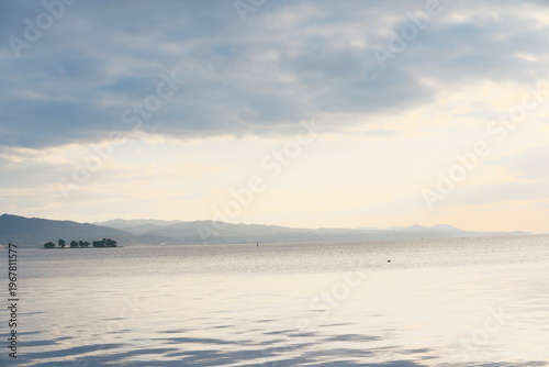 宍道湖の静寂の湖面に映る山並みと空、鳥が泳ぐ水面
