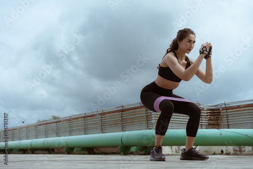 Woman performs squats outdoors.