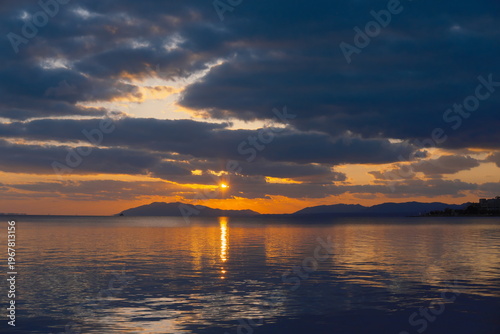 茜色の空と湖、島影に沈む夕日 - 幻想的な光景