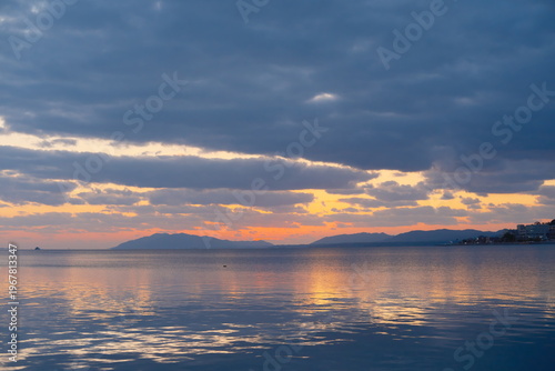 宍道湖の夕暮れ時の穏やかな湖と空、水平線に浮かぶ街並み