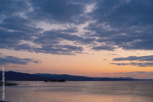 宍道湖の静寂の湖面に映る夕暮れの空と島影、水面に広がる光の道