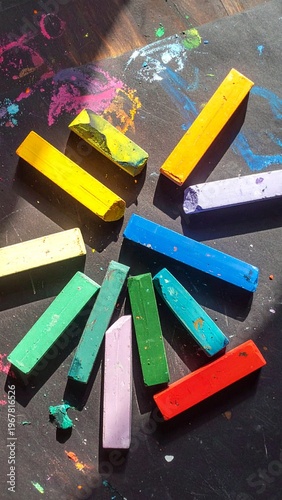 Vibrant Pastel Chalks Arranged in a Sunburst Pattern on a Dark, Artistic Surface.