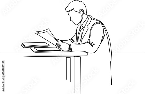 Businessman reading documents at desk.