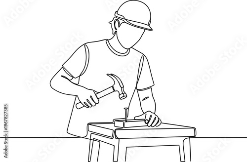 Man in hard hat hammering metal.