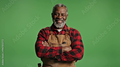 Smiling senior man with gray hair and beard wearing apron against green screen