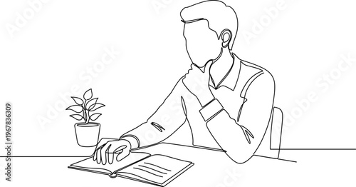 Man sitting at desk with book.