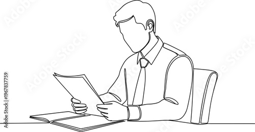 Businessman reading documents at desk.