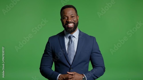 Smiling Businessman Waving Hand in Front of Green Screen