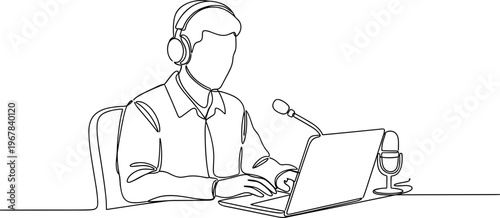 Man wearing headset working on laptop.