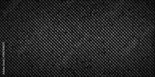 Close up of a dark textured fabric with a repeating geometric pattern