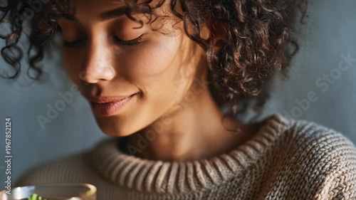 Woman enjoying herbal tea moment relaxation.