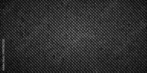 Close up of a dark textured surface resembling woven carbon fiber