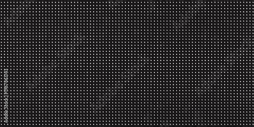 A dense uniform pattern of small circular perforations on a black surface