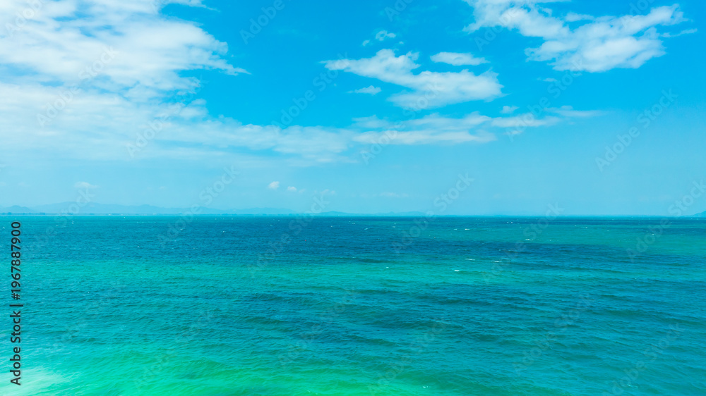 Fototapeta premium Tropical Nature clear sky and summer sea water under a clear blue sky with beautiful clouds and bright sunlight. Perfect for summer vacation and travel background