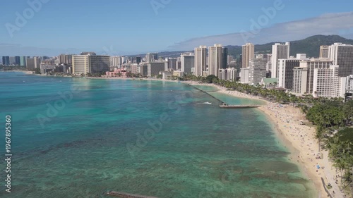 Flying above ocean along Waikiki Beach and city park, Honolulu