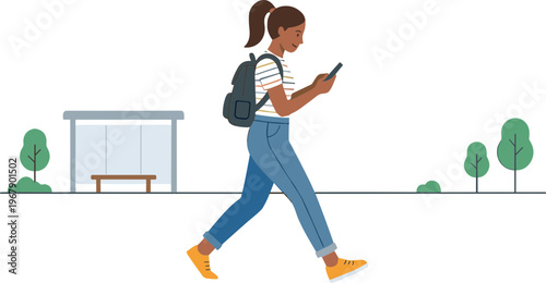 A woman walks down a city street while looking at her phone.