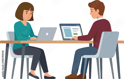 Two colleagues work together on laptops at a table indoors