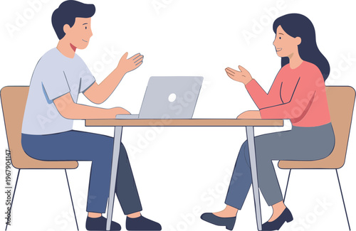 Two people sitting at a table discussing on a laptop