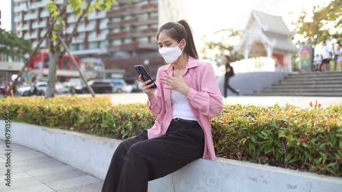 Person wearing mask in toxic urban air, monitoring pollution levels on device, highlighting health risks, environmental hazards, smog, and city pollution concerns.
