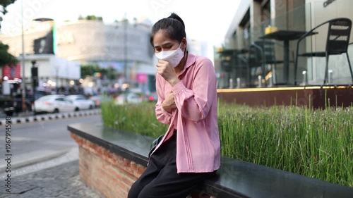 Person wearing mask in toxic urban air, monitoring pollution levels on device, highlighting health risks, environmental hazards, smog, and city pollution concerns.
