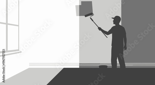 Silhouette of a professional painter using a paint roller to renovate an interior room wall